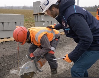 Un ostéopathe formateur corrige la technique de protection d'un homme qui travail