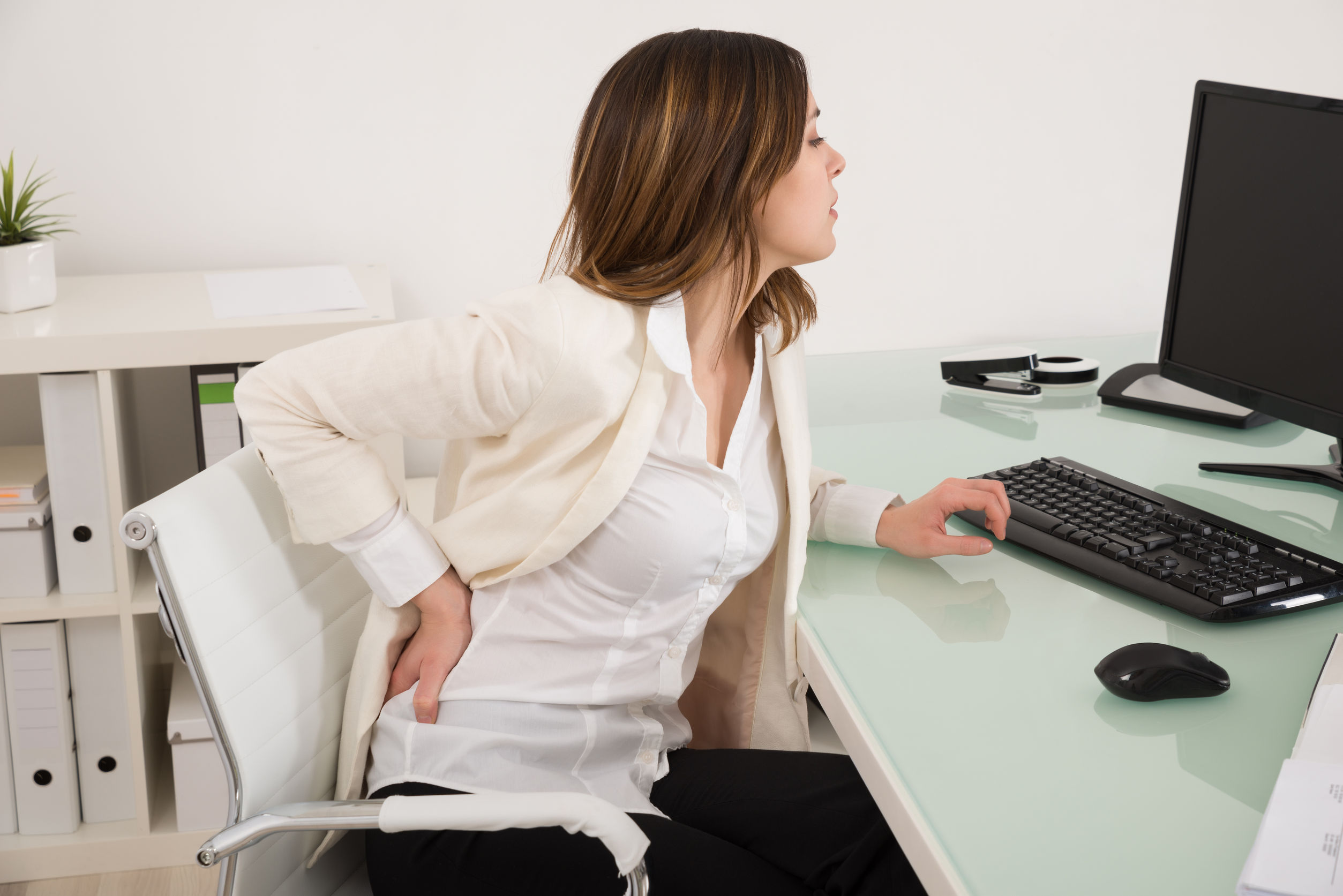 52951799 - young businesswoman suffering from backache in office