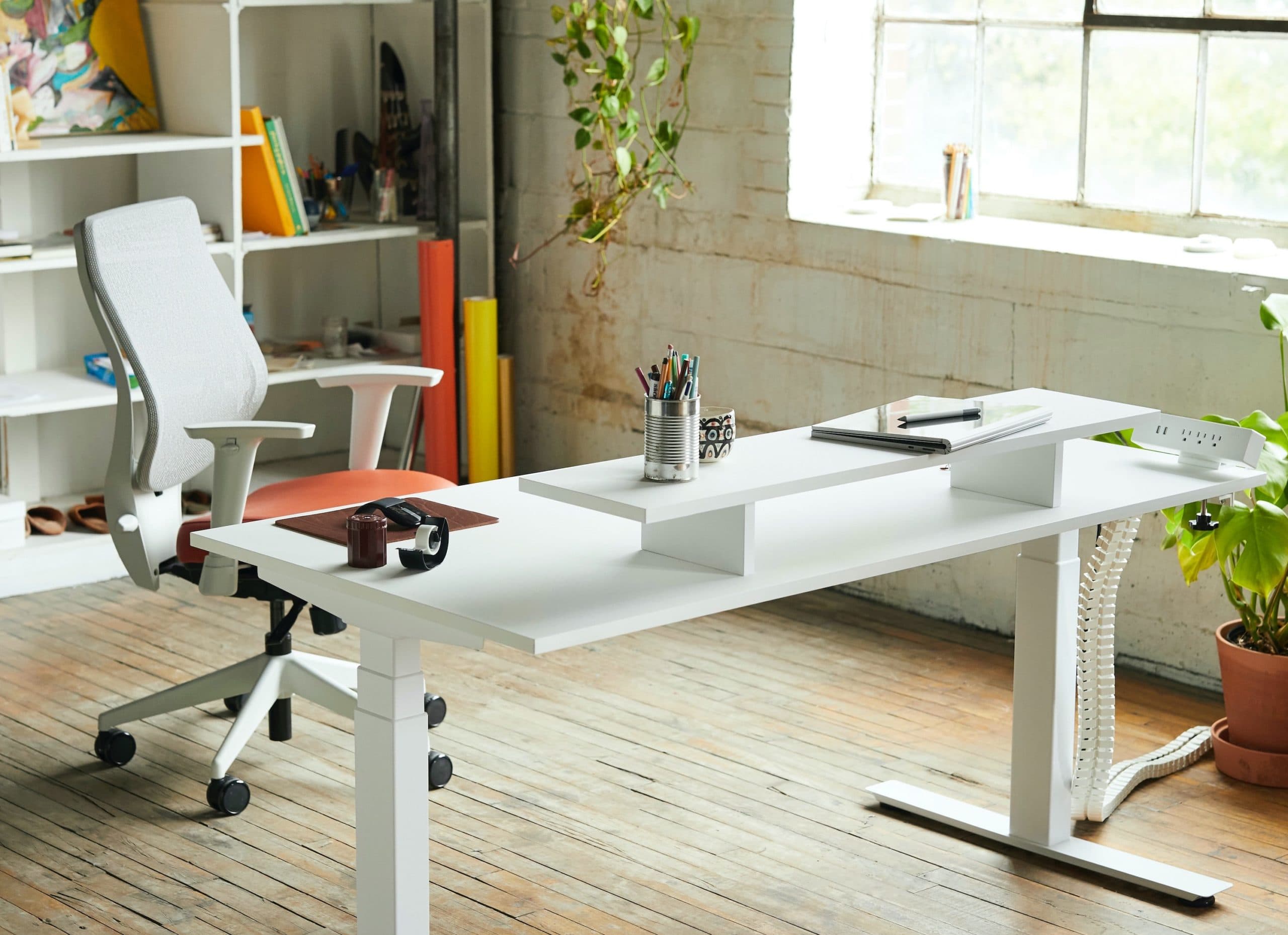 Bureau ergonomique blanc et chaise ergonomique blanche et rouge dans une pièce lumineuse