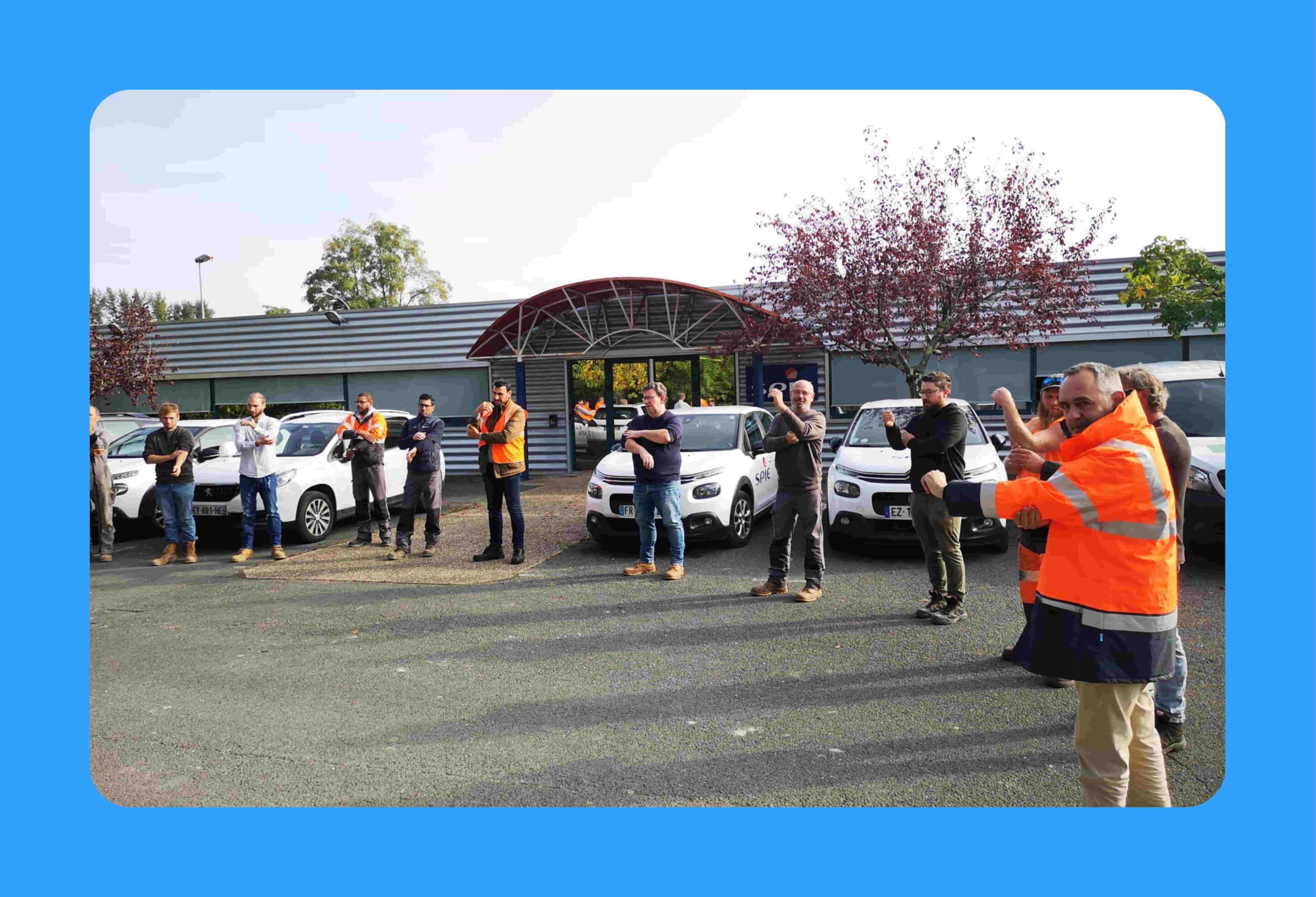 groupe qui pratique éveil musculaire groupe de salariés opérationnels qui pratiquent l'éveil musculaire sur un parking devant des voitures