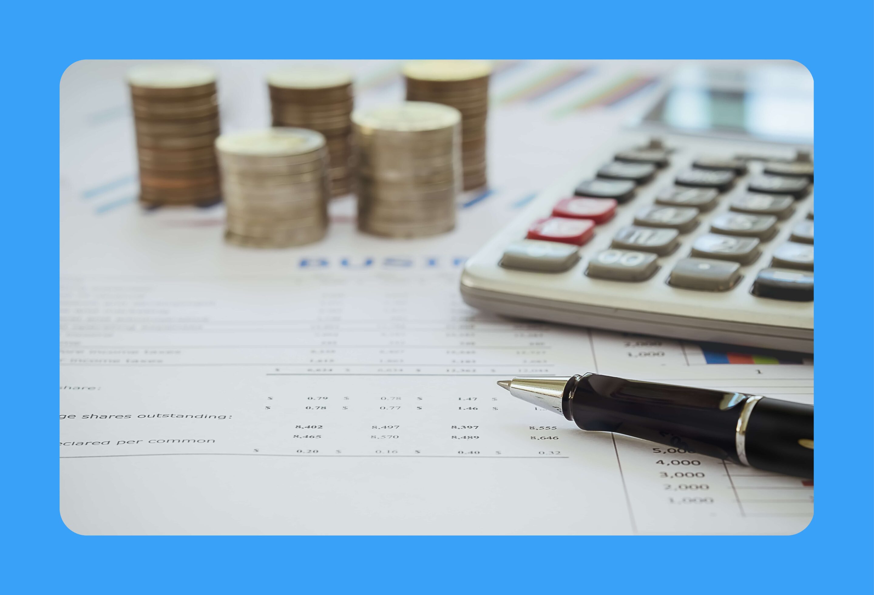 Feuille de calcul posée sur une table avec des pièces de monnaies et une calculatrice posées dessus.